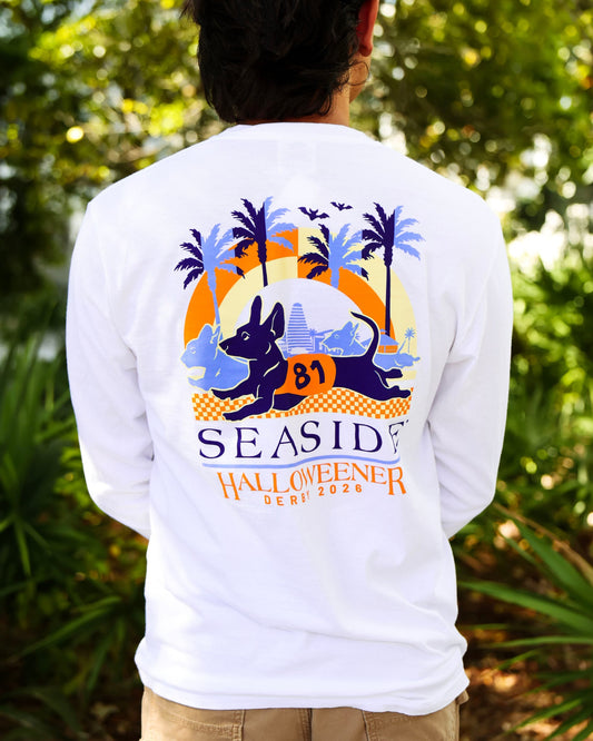 A person viewed from behind wearing a white long-sleeve graphic T-shirt outdoors. The shirt features the Seaside Halloweener Derby Logo