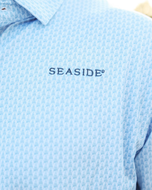 Close-up of a light blue coleman pavilion patterned button-down shirt with 'SEASIDE' embroidered in navy on the chest.