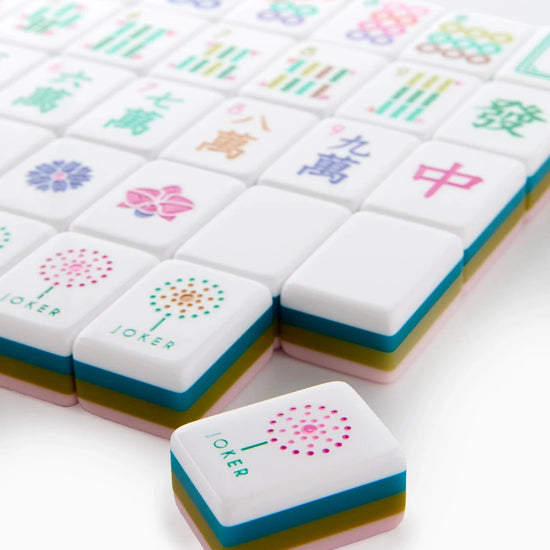 Colorful mahjong tiles with various symbols on a white background