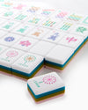 Colorful mahjong tiles with various symbols on a white background