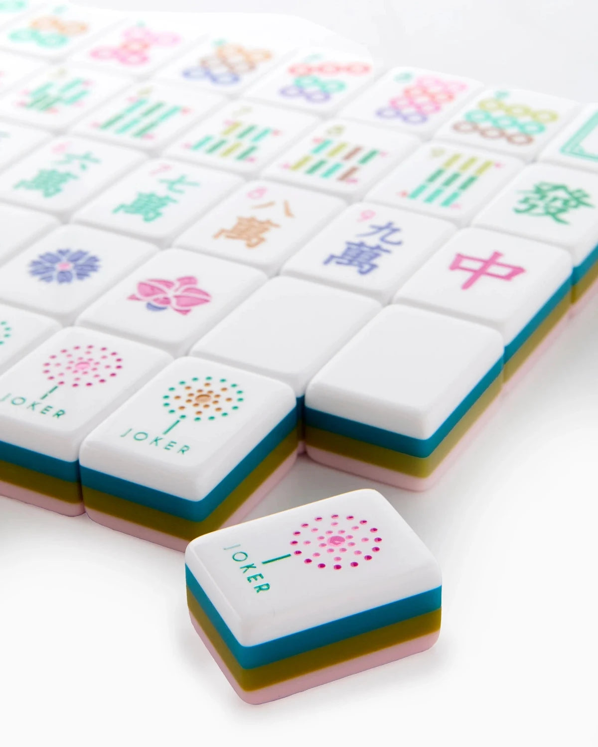 Colorful mahjong tiles with various symbols on a white background