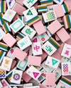 A pile of Mahjong tiles in pastel colors, including pink, white, green, blue, and yellow, with Chinese characters and traditional symbols visible on the faces of the tiles.