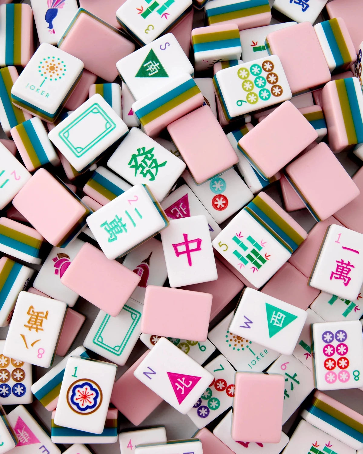 A pile of Mahjong tiles in pastel colors, including pink, white, green, blue, and yellow, with Chinese characters and traditional symbols visible on the faces of the tiles.