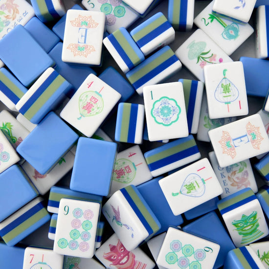 A dense pile of mahjong tiles showing various white, blue, and green patterned pieces.