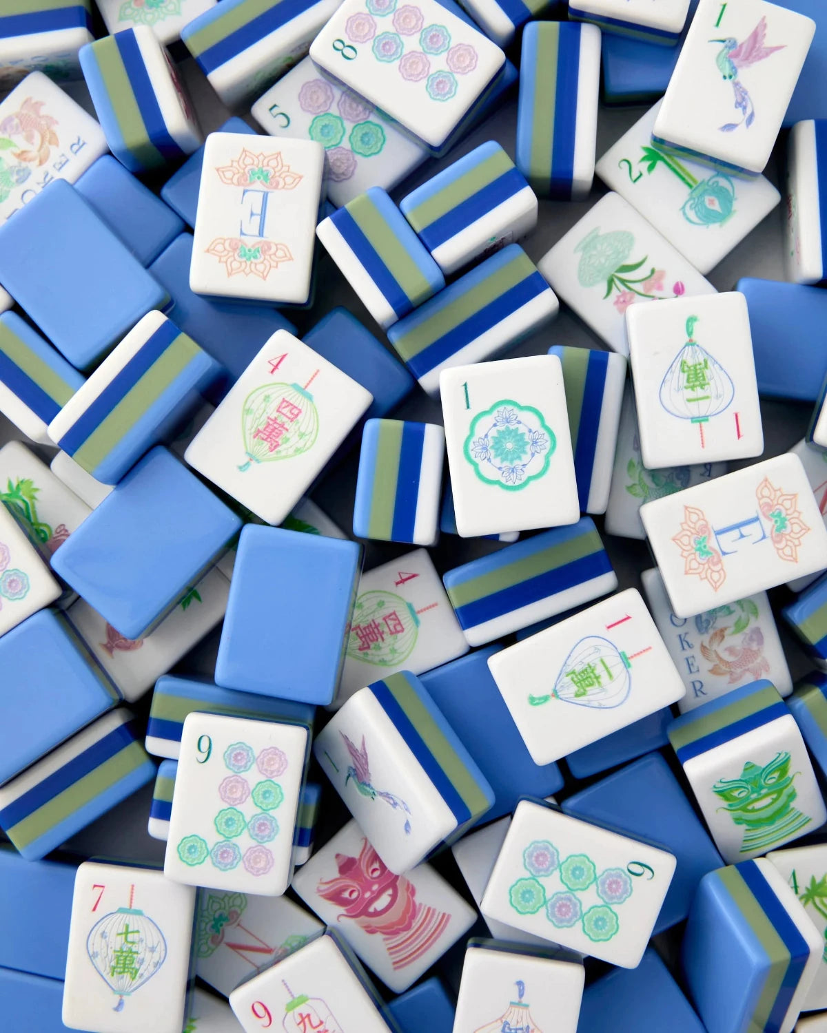 A dense pile of mahjong tiles showing various white, blue, and green patterned pieces.
