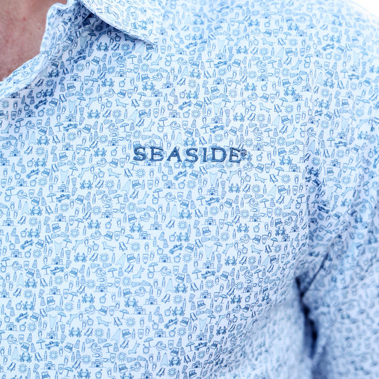Close-up of a light blue and white patterned button-down shirt with 'SEASIDE' embroidered on the chest, worn by a model.