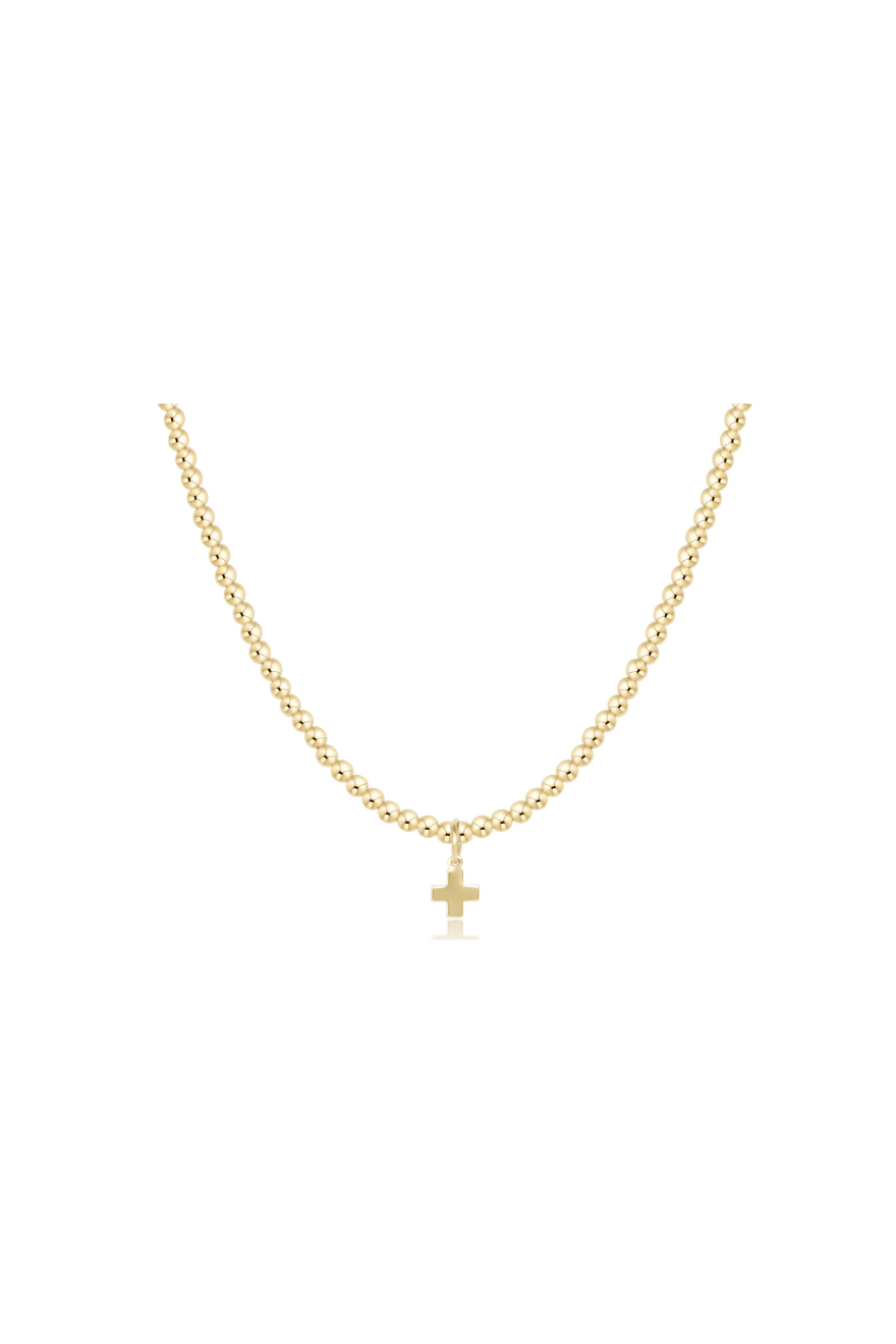 A delicate gold chain necklace with a small cross pendant, displayed against a solid white background.