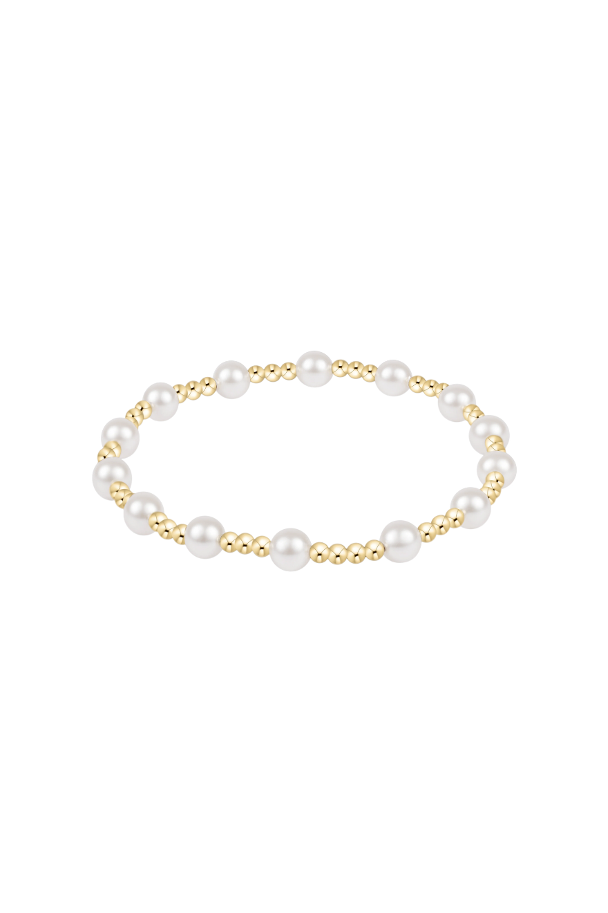 A delicate gold chain bracelet with a short, textured gold bead segment pendant, displayed on a clean white background with a soft reflection below.
