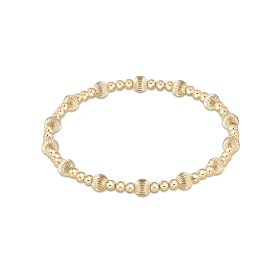 A delicate gold chain bracelet featuring a central cluster of three textured, ridged gold beads, presented on a clean white background with a subtle reflection below.