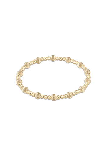 A delicate gold chain bracelet featuring a central cluster of three textured, ridged gold beads, presented on a clean white background with a subtle reflection below.