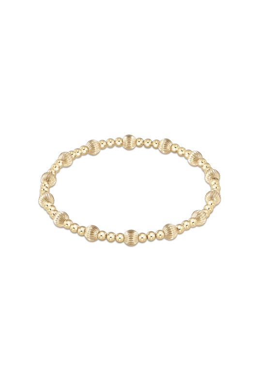 A delicate gold chain bracelet featuring a central cluster of three textured, ridged gold beads, presented on a clean white background with a subtle reflection below.