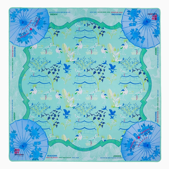 Decorative mahjong mat with floral and umbrella design on a light blue background